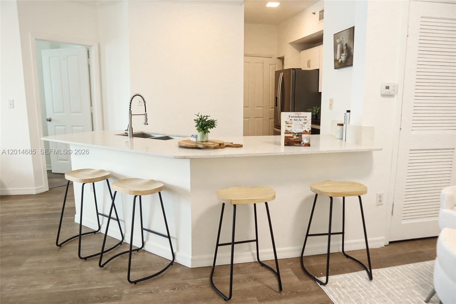 9172 Collins Avenue, Unit 212 Surfside, FL 33154 - Photo 11 of 23 a kitchen with stainless steel appliances kitchen island granite countertop a table and chairs in it