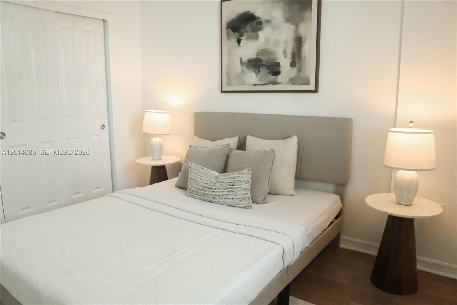 9172 Collins Avenue, Unit 212 Surfside, FL 33154 - Photo 2 of 23 a bedroom with a bed and a lamp