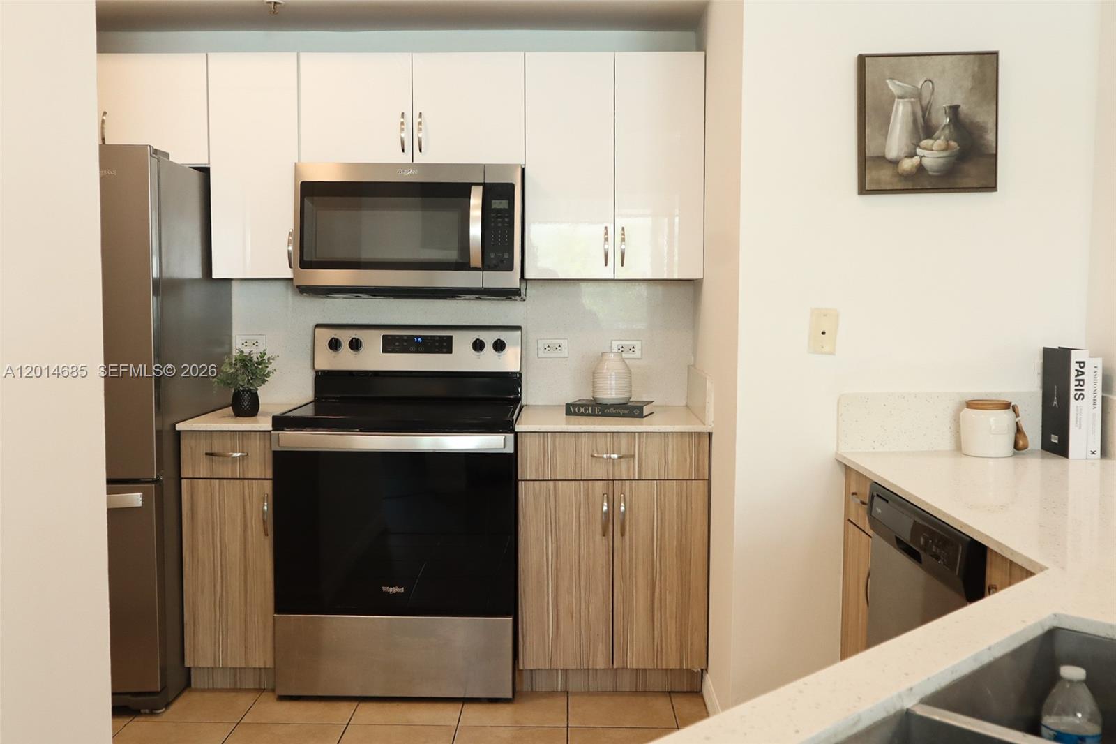 9172 Collins Avenue, Unit 212 Surfside, FL 33154 - Photo 9 of 23 a kitchen with stainless steel appliances a stove a microwave and a refrigerator