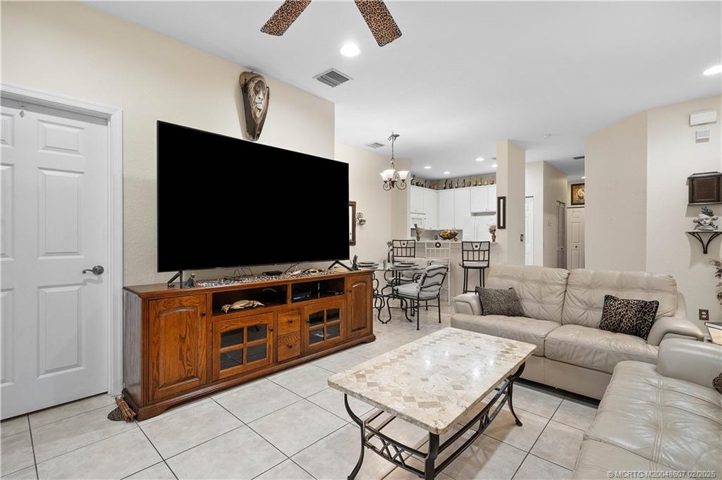 1580 Southeast Sheffield Terrace, Unit 101 Stuart, FL 34994 - Photo 13 of 39 a living room with furniture and a flat screen tv
