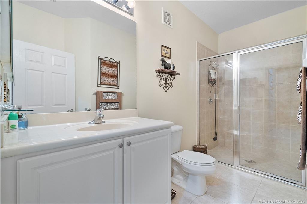 1580 Southeast Sheffield Terrace, Unit 101 Stuart, FL 34994 - Photo 19 of 39 a bathroom with a sink a toilet and shower