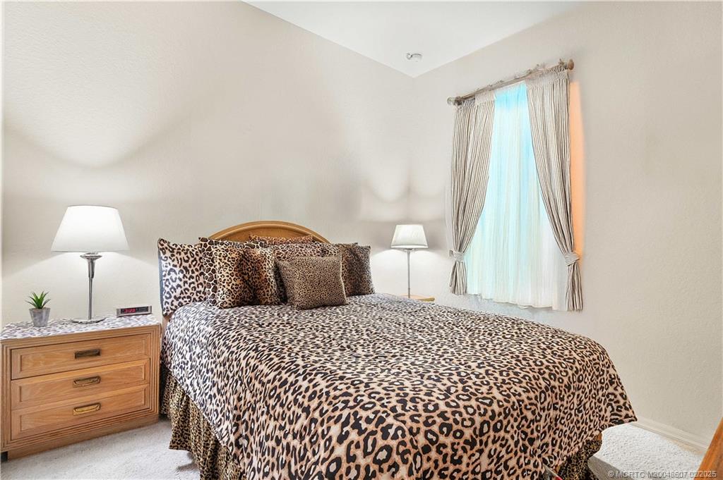 1580 Southeast Sheffield Terrace, Unit 101 Stuart, FL 34994 - Photo 20 of 39 a bedroom with a bed and a window