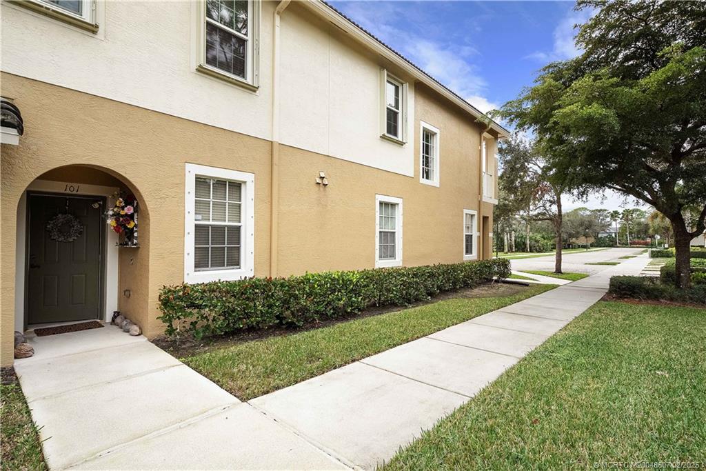 1580 Southeast Sheffield Terrace, Unit 101 Stuart, FL 34994 - Photo 4 of 39 a view of a brick house with a yard