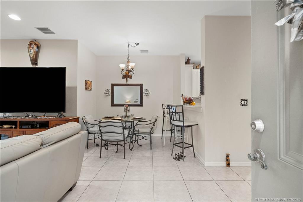 1580 Southeast Sheffield Terrace, Unit 101 Stuart, FL 34994 - Photo 10 of 39 a living room with furniture and a flat screen tv