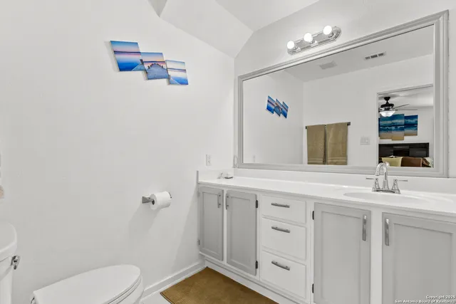 a bathroom with a toilet sink and mirror