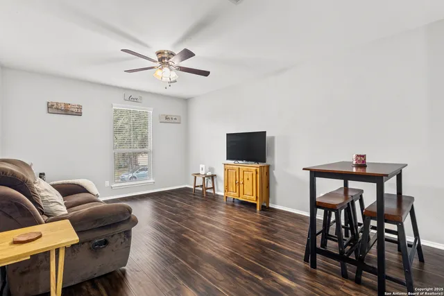 a living room with furniture a flat screen tv and a window