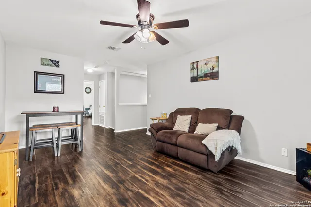 a living room with furniture and a wooden floor