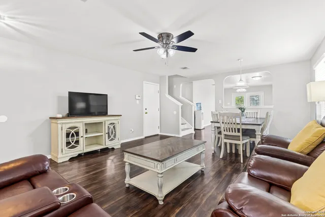 a living room with furniture a flat screen tv and kitchen view