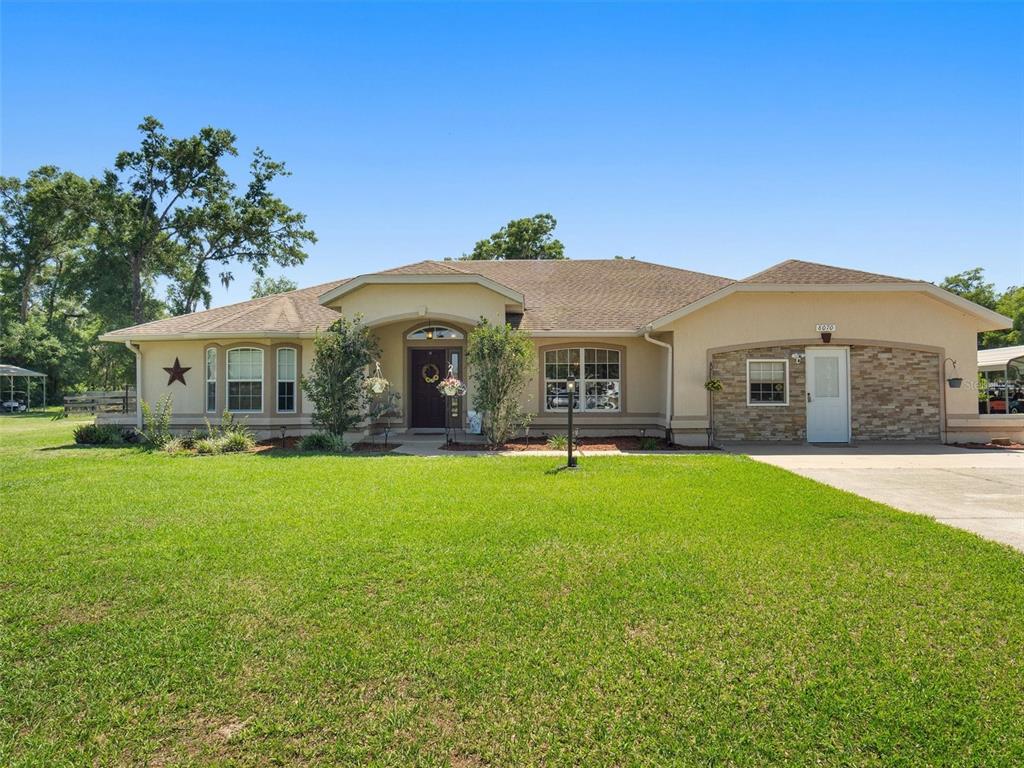 8070 Southwest 41st Place Road Ocala, FL 34481 - Photo 1 of 1 a front view of a house with a garden