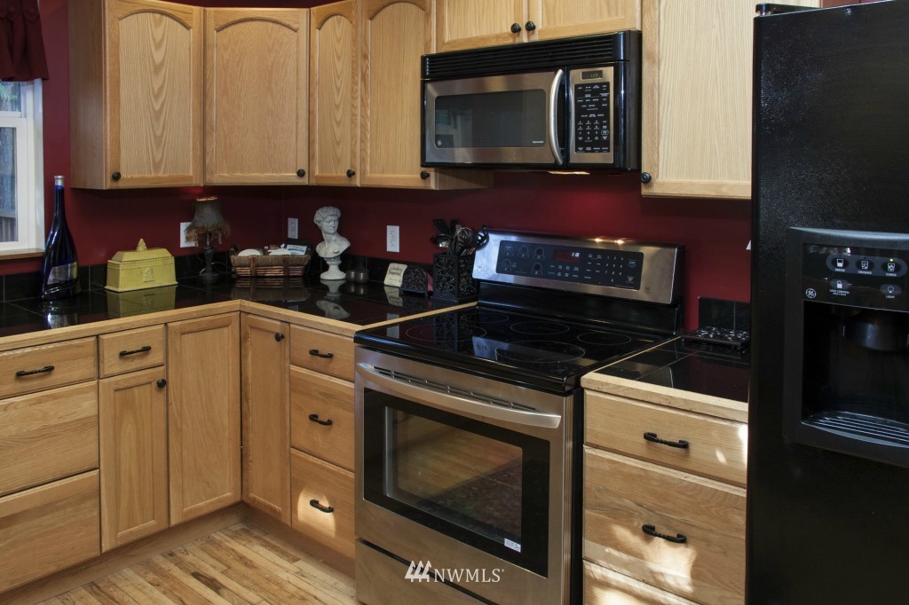 16623 Benson Road South Renton, WA 98055 - Photo 13 of 20 a kitchen with granite countertop a stove and a microwave