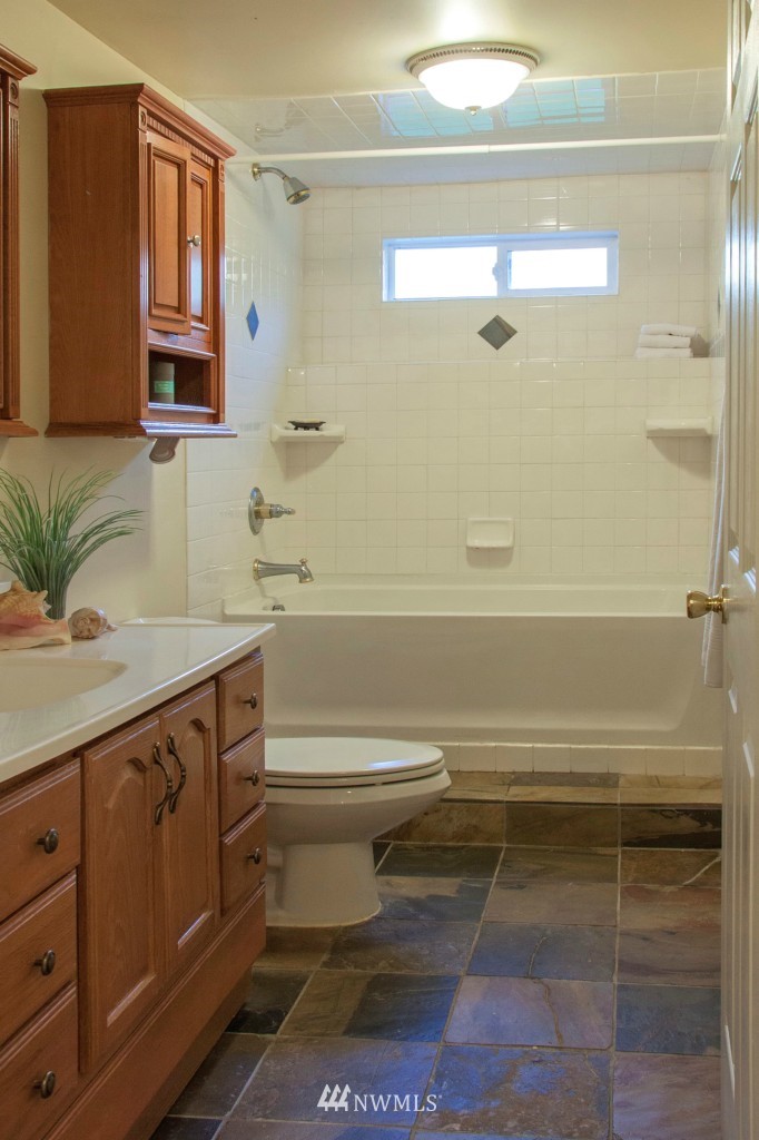 16623 Benson Road South Renton, WA 98055 - Photo 8 of 20 a bathroom with a bathtub shower sink vanity and a toilet