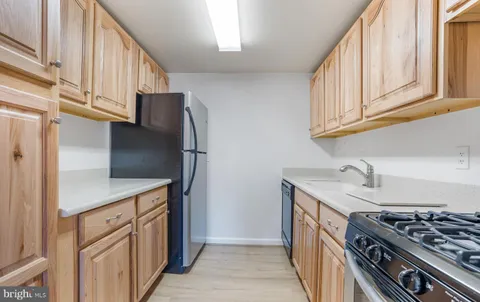 a kitchen with white cabinets and appliances