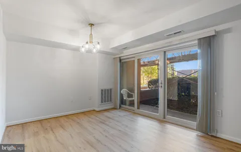 a view of an empty room with glass door and a window