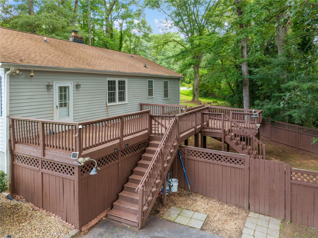 98 Blue Ridge Drive Clemson, SC 29631 - Photo 27 of 32 Multi-level wooden decking overlooks a fenced yard bordered by mature trees.