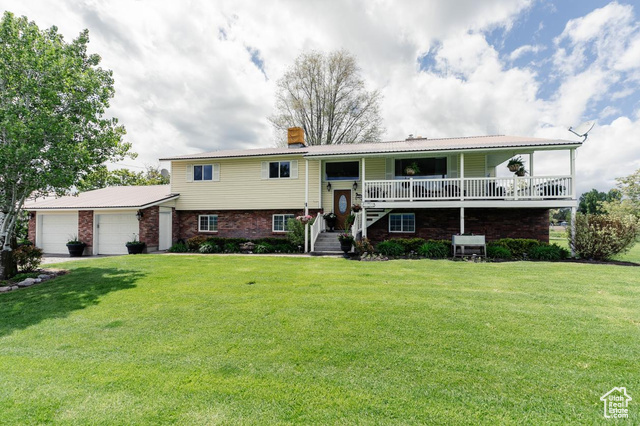3704 South State Street Preston, ID 83263 - Photo 1 of 1 Bi-level home featuring an attached garage, a chimney, a front lawn, brick siding, and metal roof