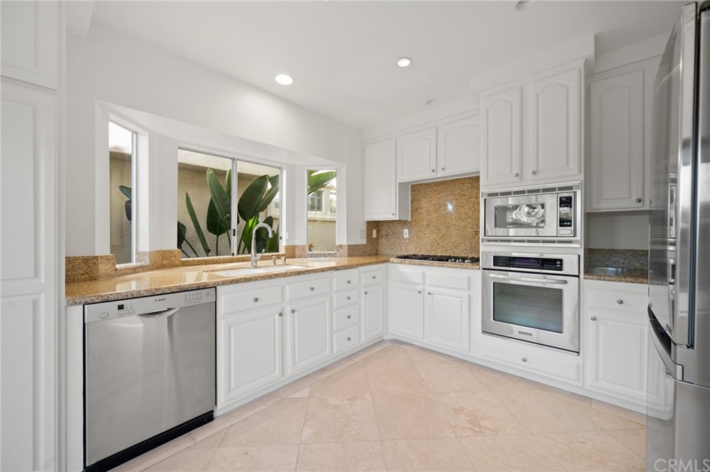 17 St John Dana Point, CA 92629 - Photo 13 of 28 a kitchen with granite countertop white cabinets and stainless steel appliances