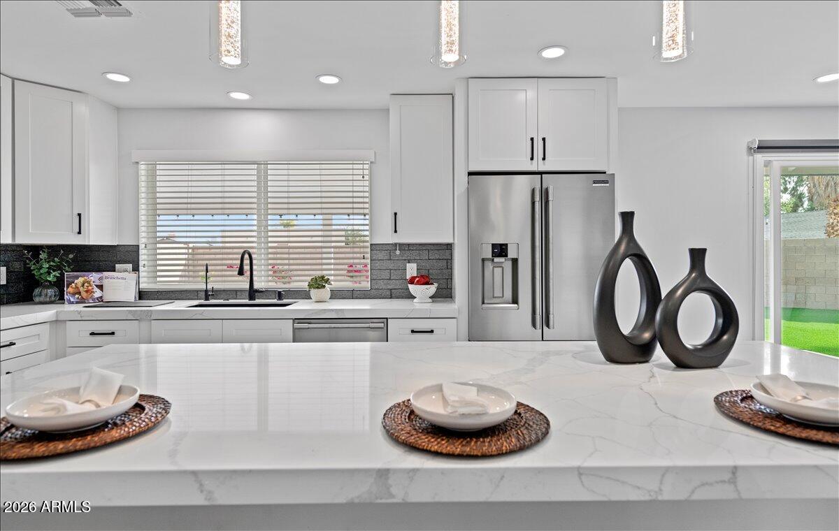 11615 North 30th Street Phoenix, AZ 85028 - Photo 9 of 37 a kitchen with refrigerator and white wooden cabinets