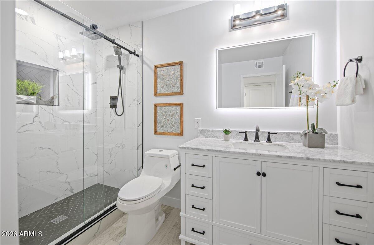 11615 North 30th Street Phoenix, AZ 85028 - Photo 16 of 37 a bathroom with a granite countertop sink toilet a shower and a mirror