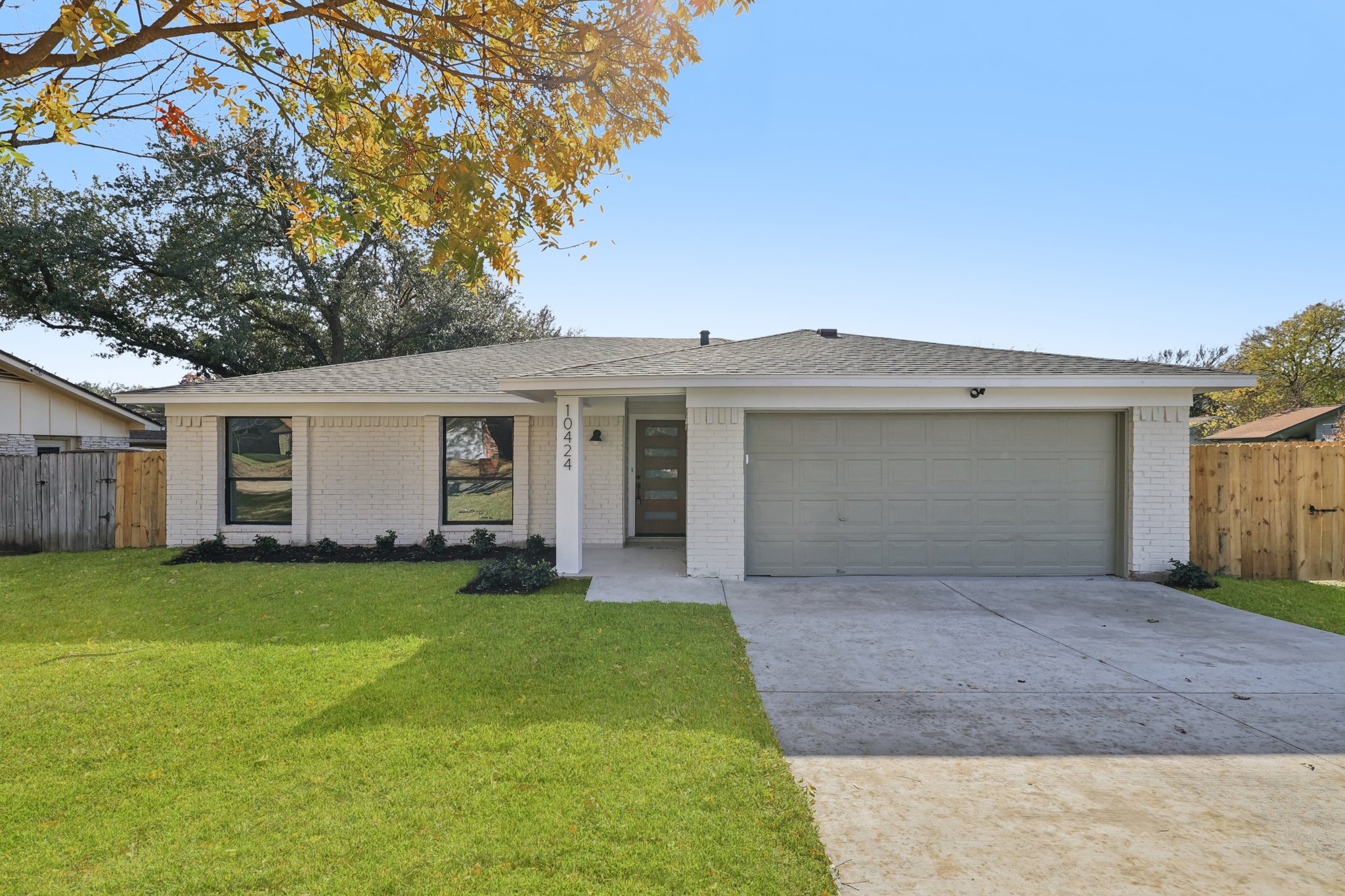 a front view of a house with a yard and trees