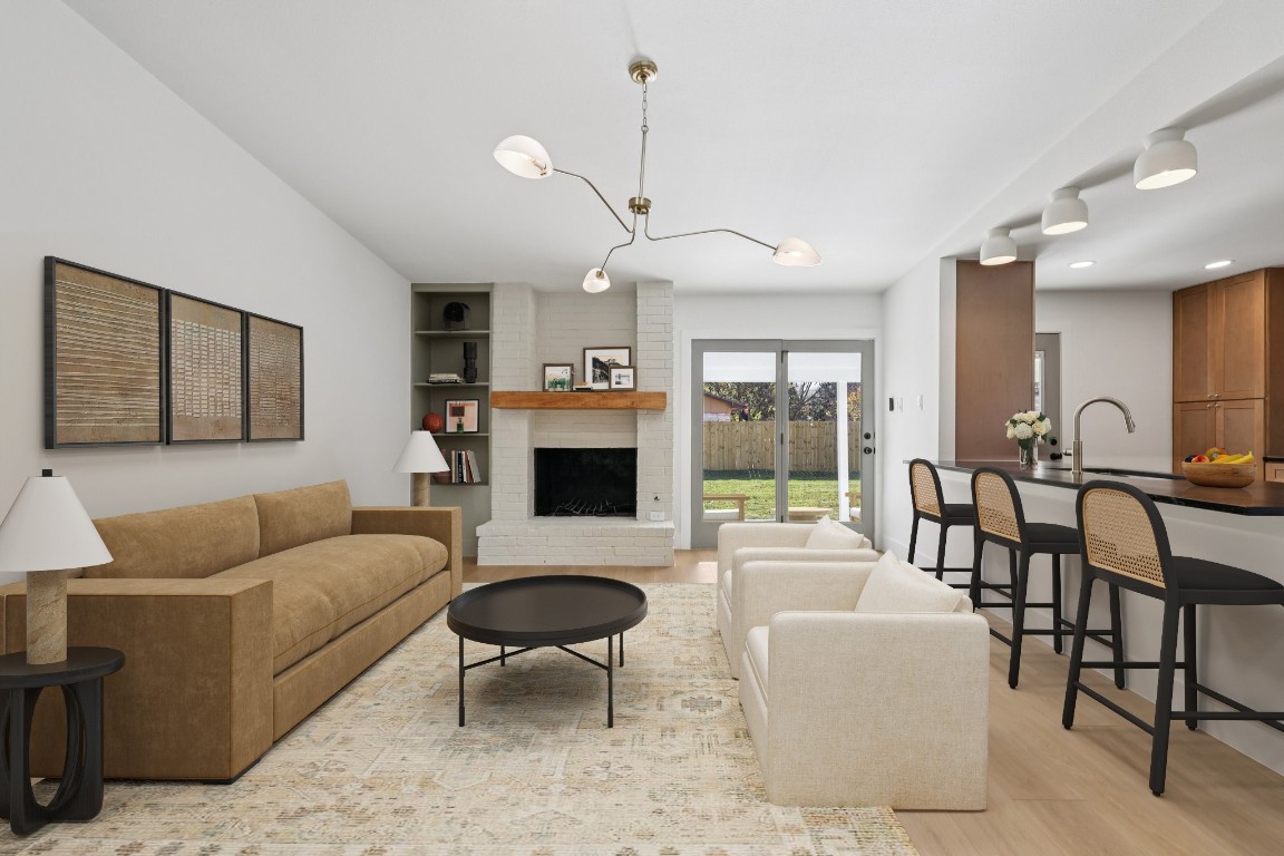 10424 Quail Ridge Drive Austin, TX 78758 - Photo 2 of 37 Living area with a brick fireplace and light wood-style floors