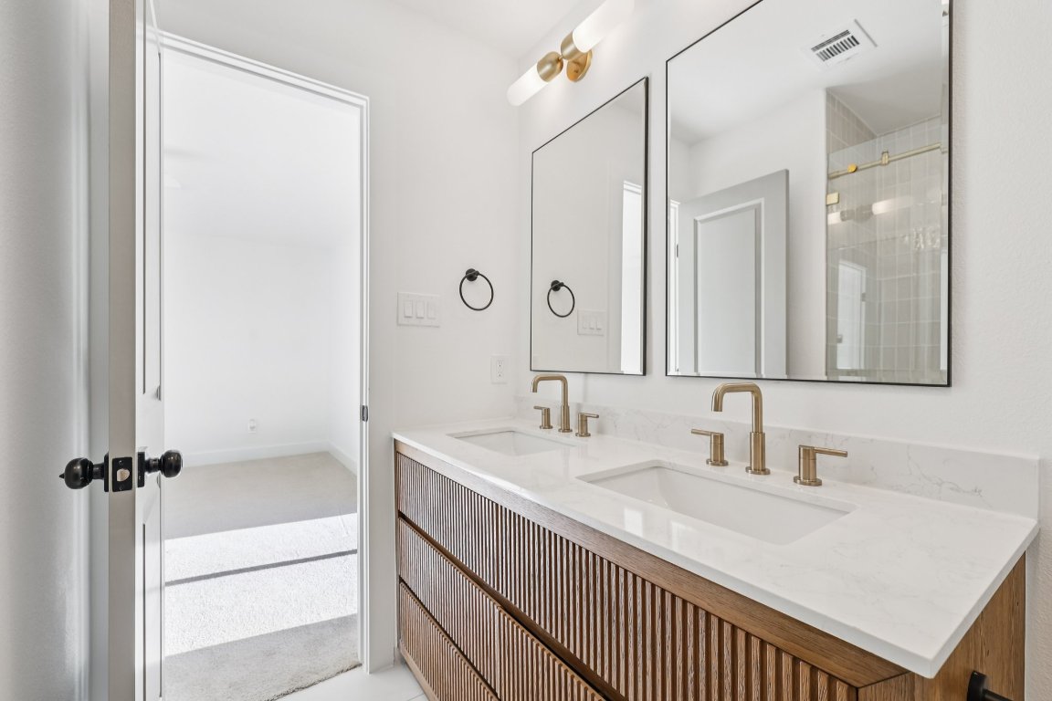 10424 Quail Ridge Drive Austin, TX 78758 - Photo 18 of 37 Bathroom with double vanity, a shower with door, and light carpet