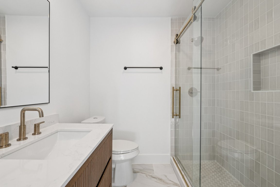 10424 Quail Ridge Drive Austin, TX 78758 - Photo 19 of 37 Full bathroom featuring vanity, light marble finish floors, and a stall shower