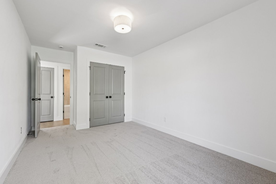 10424 Quail Ridge Drive Austin, TX 78758 - Photo 20 of 37 Unfurnished bedroom featuring a closet and light colored carpet