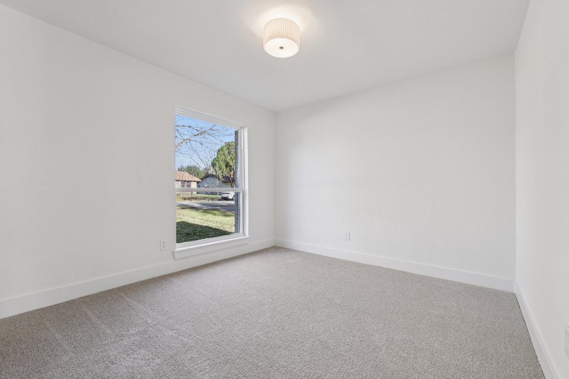10424 Quail Ridge Drive Austin, TX 78758 - Photo 24 of 37 Carpeted empty room featuring baseboards