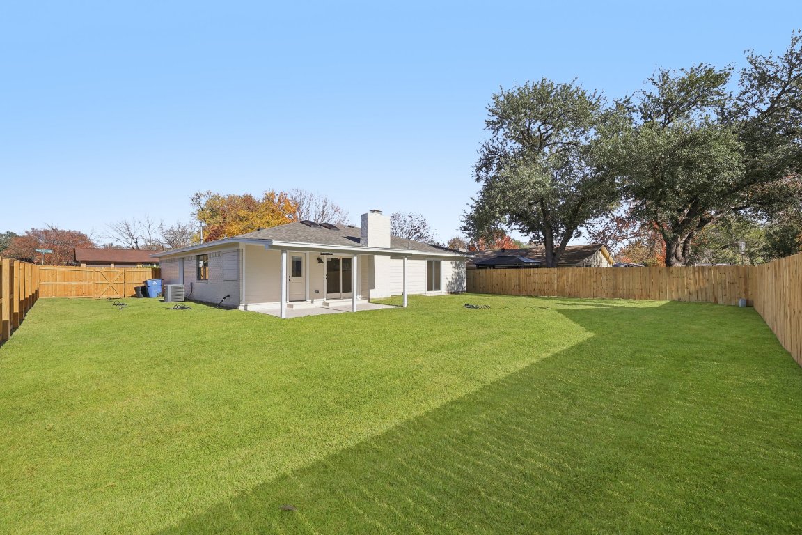 10424 Quail Ridge Drive Austin, TX 78758 - Photo 25 of 37 Back of house with a fenced backyard, a patio area, and a chimney