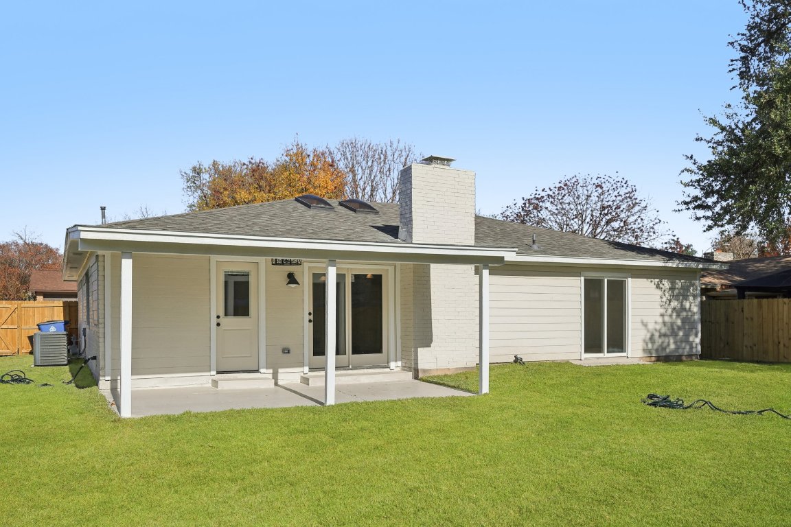 10424 Quail Ridge Drive Austin, TX 78758 - Photo 26 of 37 Back of property with a chimney, roof with shingles, a patio area, and brick siding