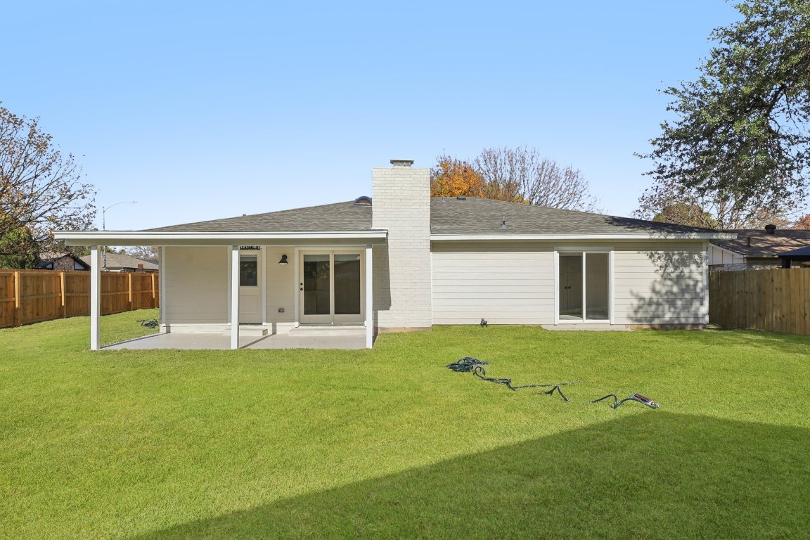 10424 Quail Ridge Drive Austin, TX 78758 - Photo 27 of 37 Rear view of house featuring a fenced backyard, a chimney, a patio, and a shingled roof