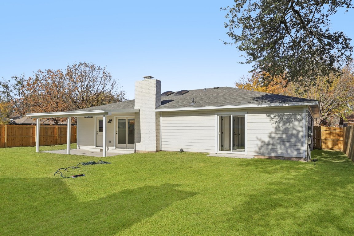 10424 Quail Ridge Drive Austin, TX 78758 - Photo 30 of 37 Rear view of property featuring a fenced backyard, a patio, a chimney, and a shingled roof