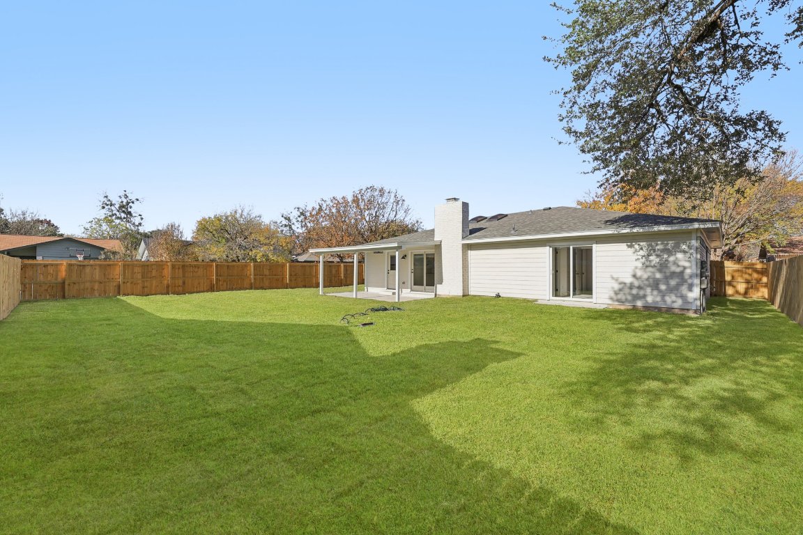 10424 Quail Ridge Drive Austin, TX 78758 - Photo 31 of 37 Rear view of property with a patio area, a fenced backyard, and a chimney