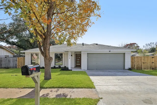 a front view of a house with a garden and trees