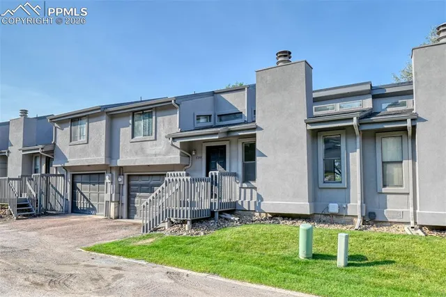 a view of a house with a yard and a large tree