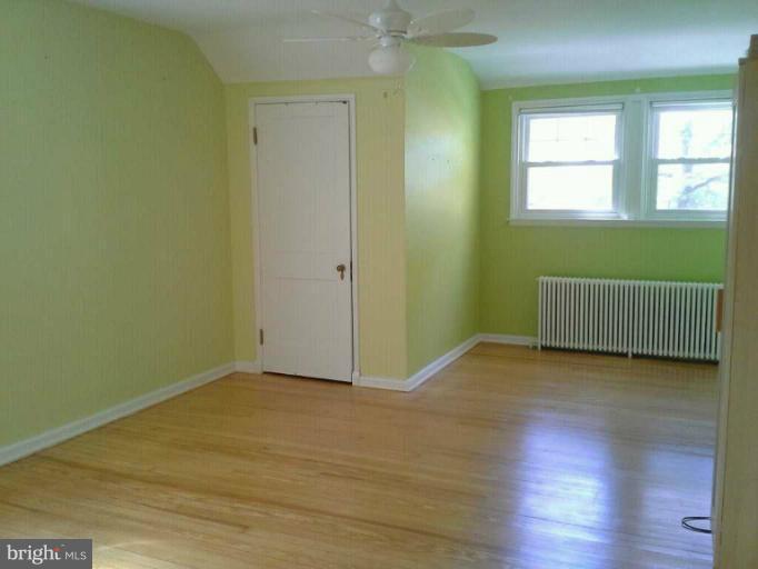 421 Rolling Rd. Catonsville, MD 21228 - Photo 15 of 26 a view of an empty room with wooden floor and a window