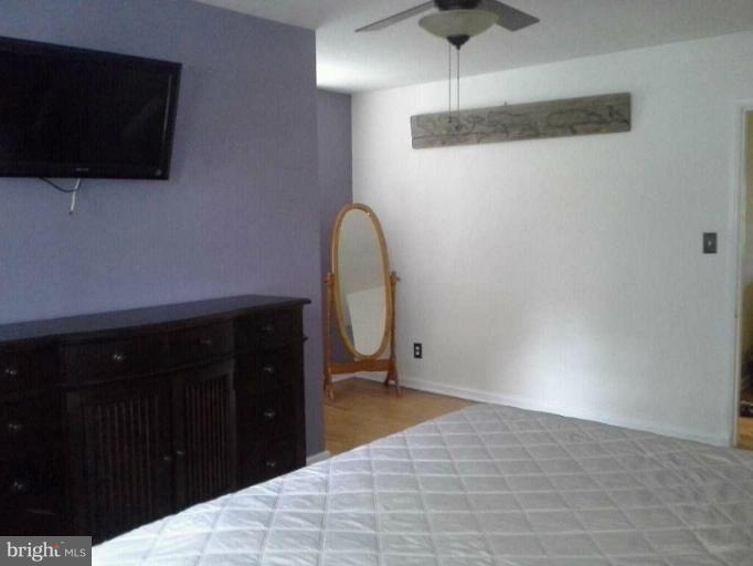 421 Rolling Rd. Catonsville, MD 21228 - Photo 18 of 26 a bedroom with a bed and a flat tv screen on the dresser