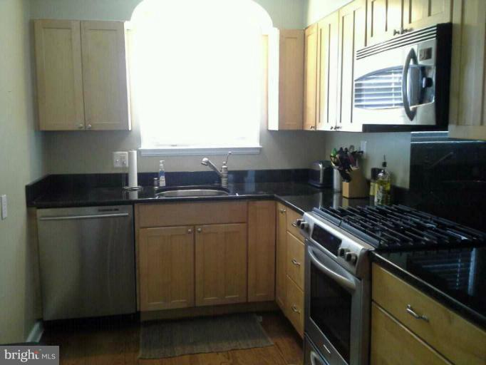 421 Rolling Rd. Catonsville, MD 21228 - Photo 4 of 26 a kitchen with stainless steel appliances granite countertop a sink stove and microwave