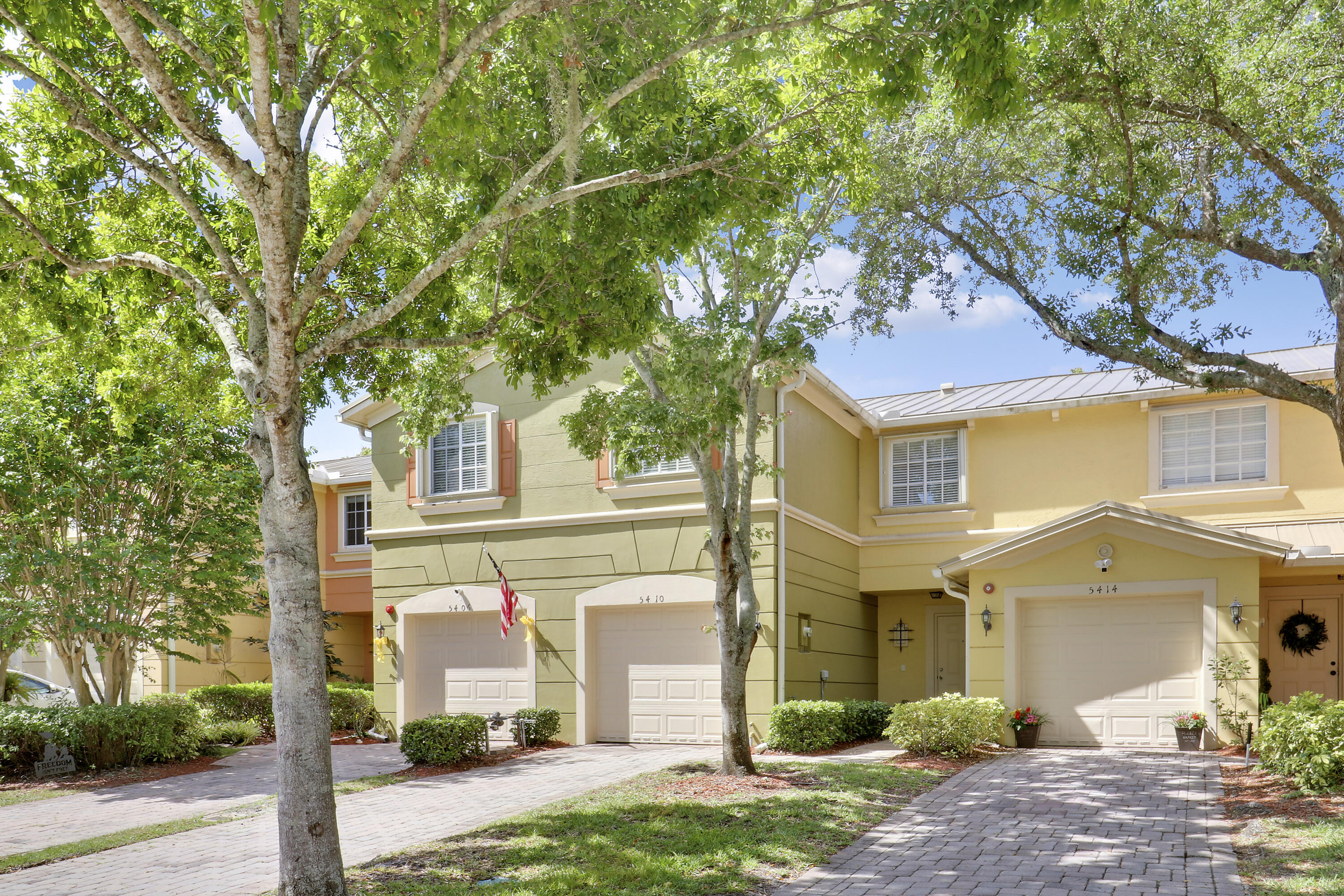 5410 Southeast Mitchell Lane Stuart, FL 34997 - Photo 2 of 24 a front view of a house with a yard and garage