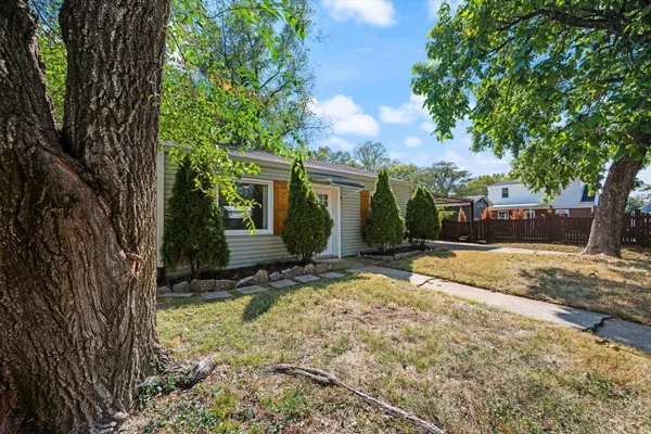 a view of a house with backyard and trees