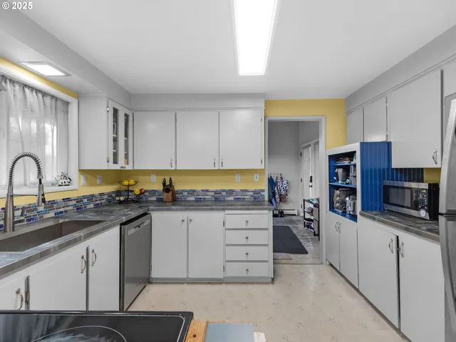 a kitchen with stainless steel appliances a sink cabinets and wooden floor
