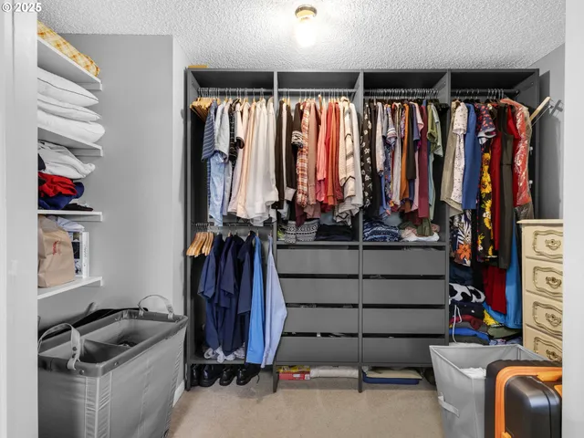 a view of walk in closet with clothes and shoes