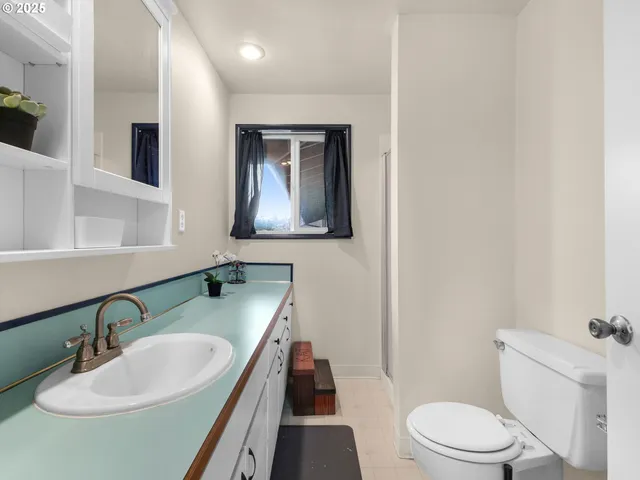 a bathroom with a granite countertop sink toilet and mirror