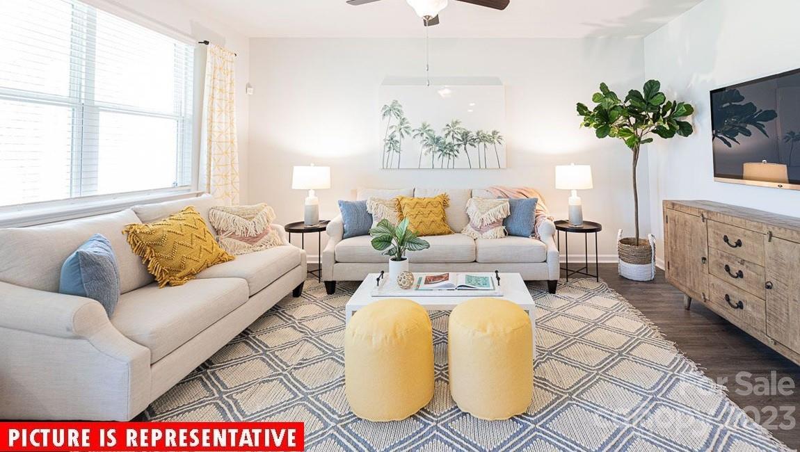 2047 Vanderlyn Street Monroe, NC 28112 - Photo 12 of 16 a living room with furniture a flat screen tv and a potted plant