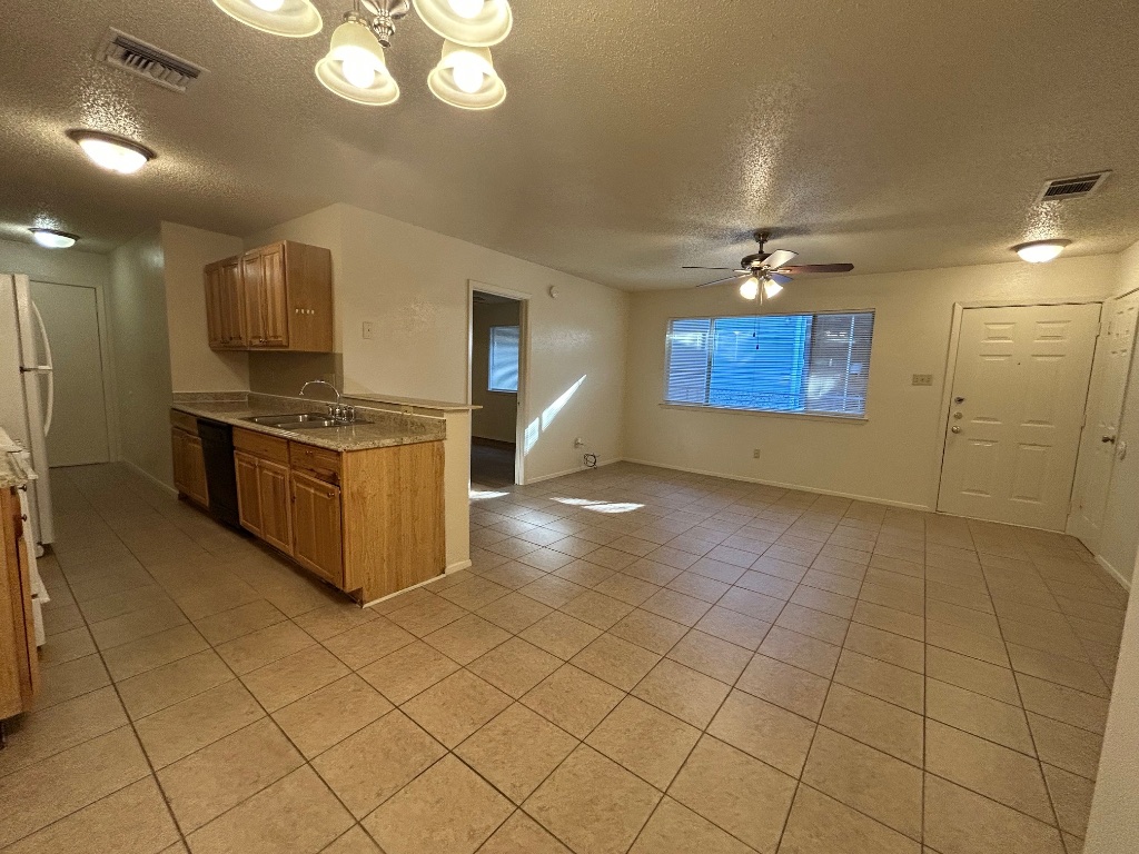 4600 Brown Bark Place, Unit A Austin, TX 78727 - Photo 5 of 18 a kitchen with stainless steel appliances a stove a sink and a refrigerator
