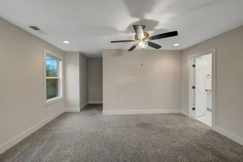 an empty room with fan and windows