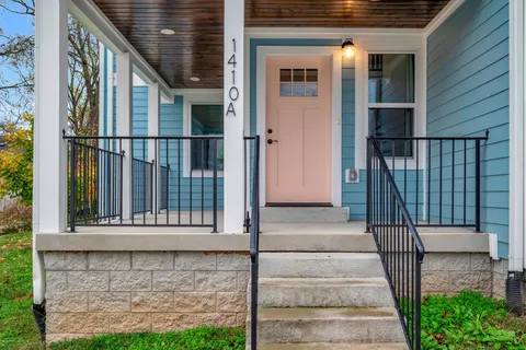 a view of entrance gate of a house with a small yard