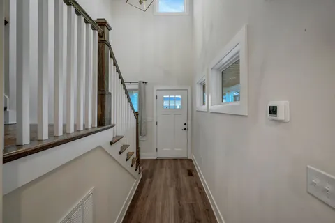 a view of a hallway with wooden floor and staircase