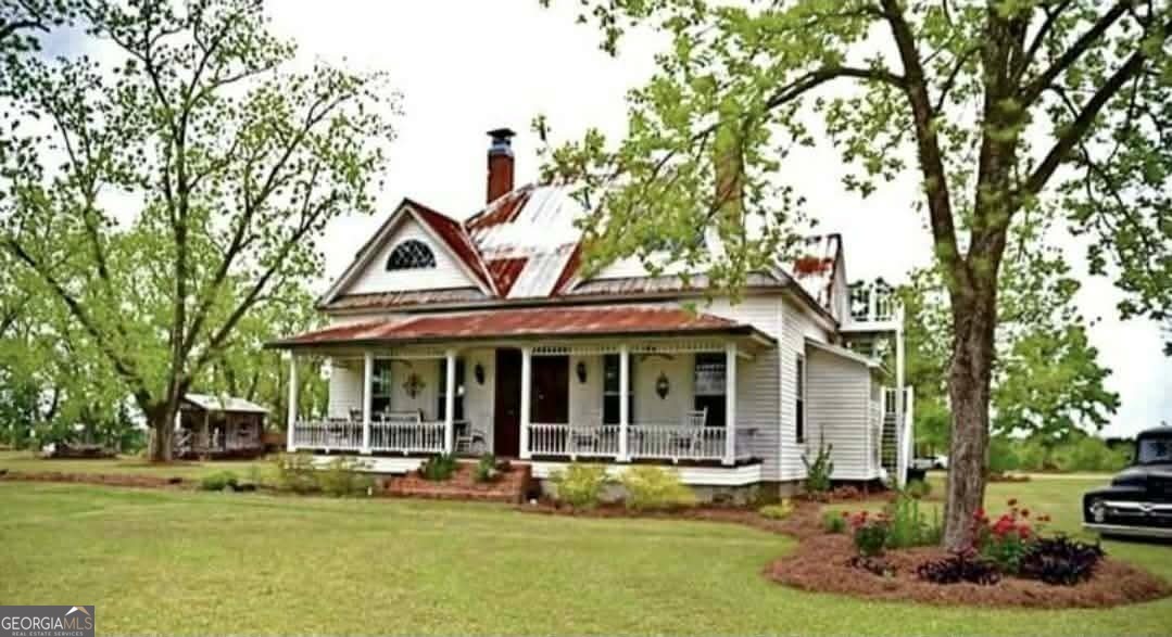 a front view of a house with a garden and trees