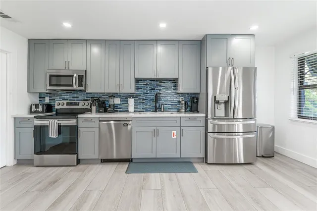 a living room with furniture kitchen view and a chandelier